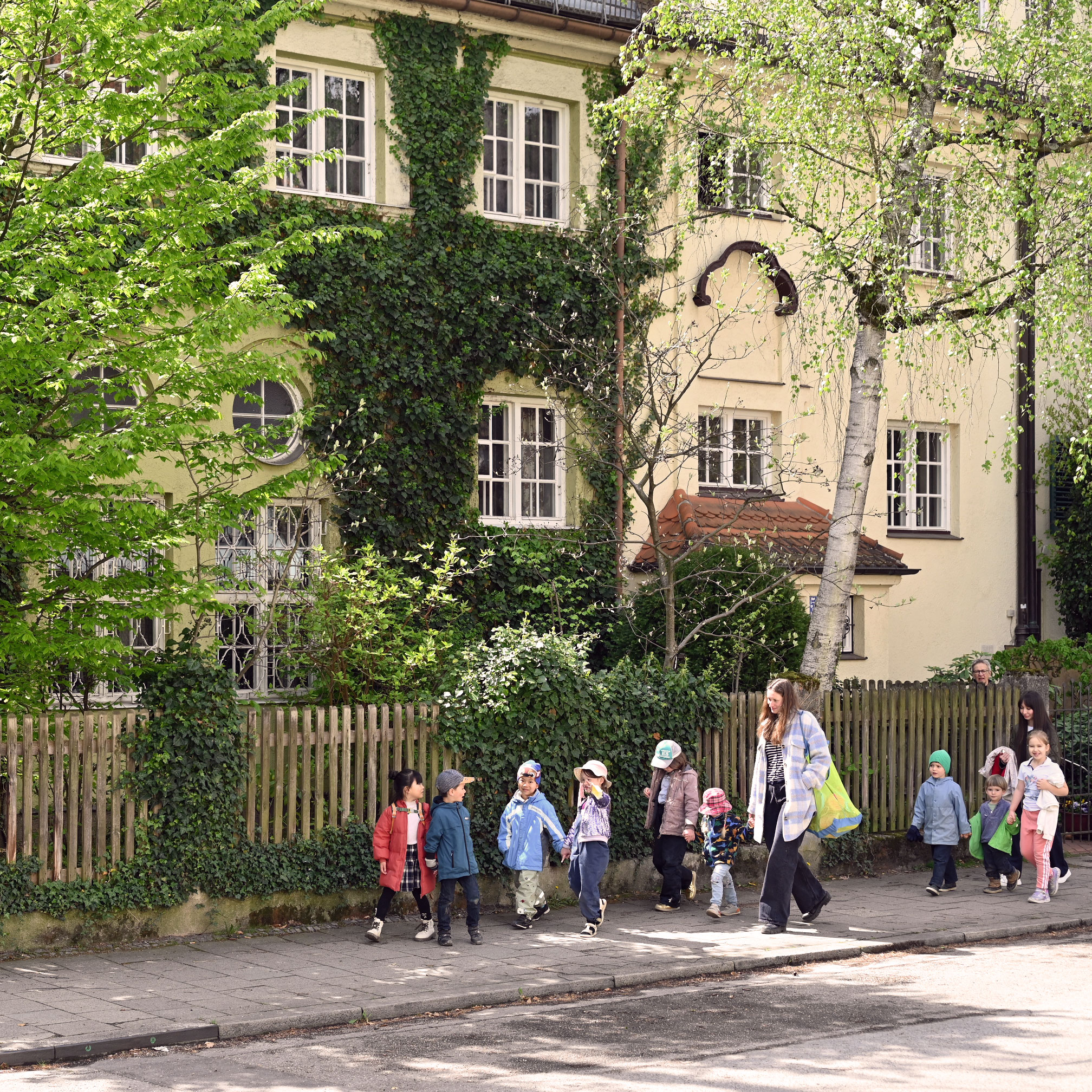 Children from bilingual preschool walking from the park